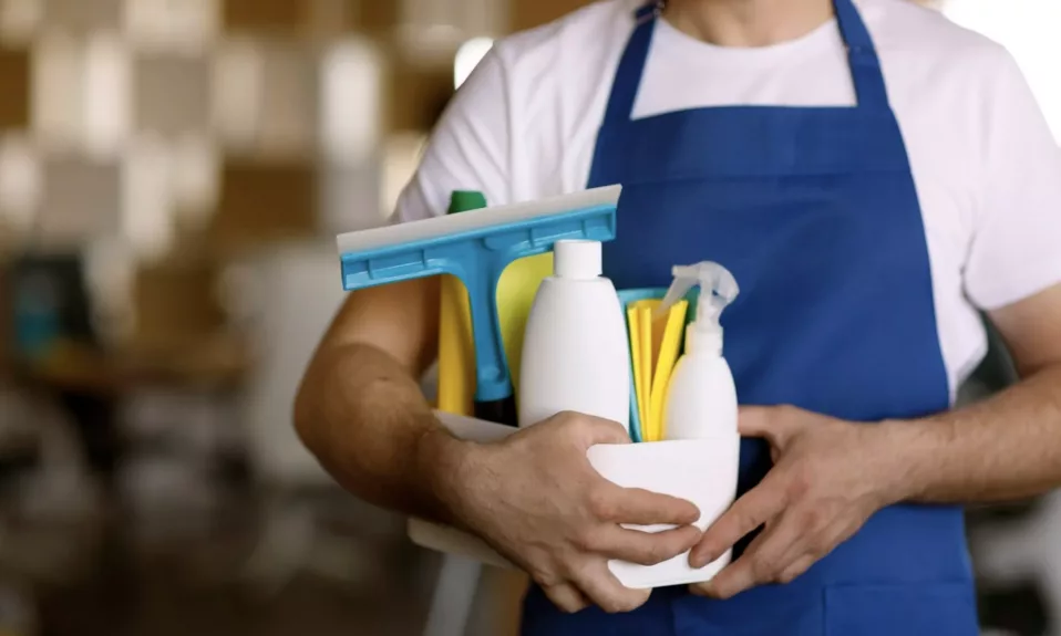 Janitor holding cleaning supplies in bucket