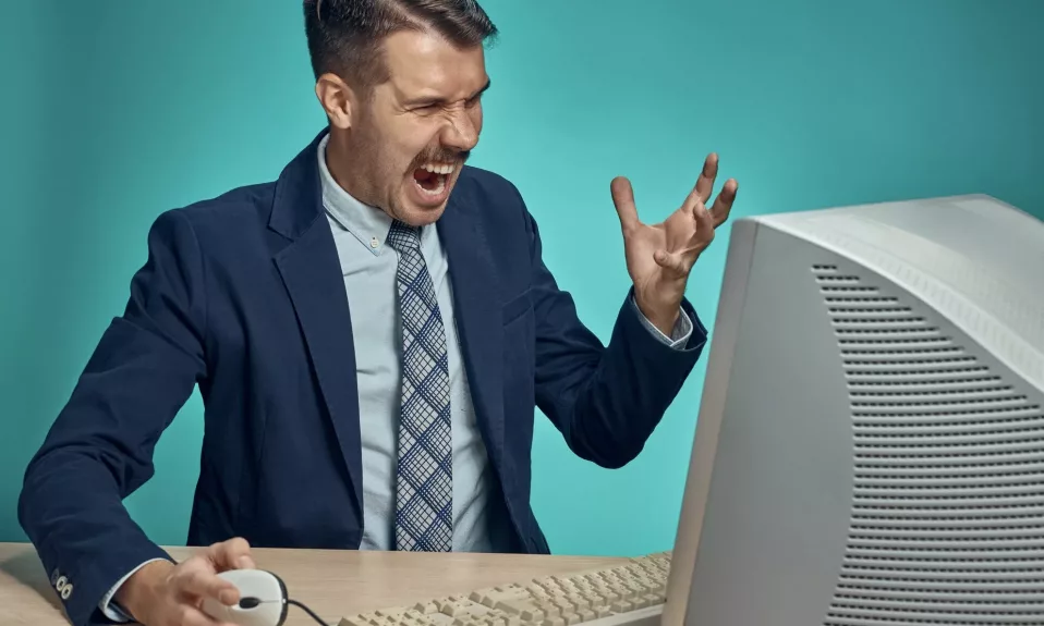 Frustrated man yelling at computer screen