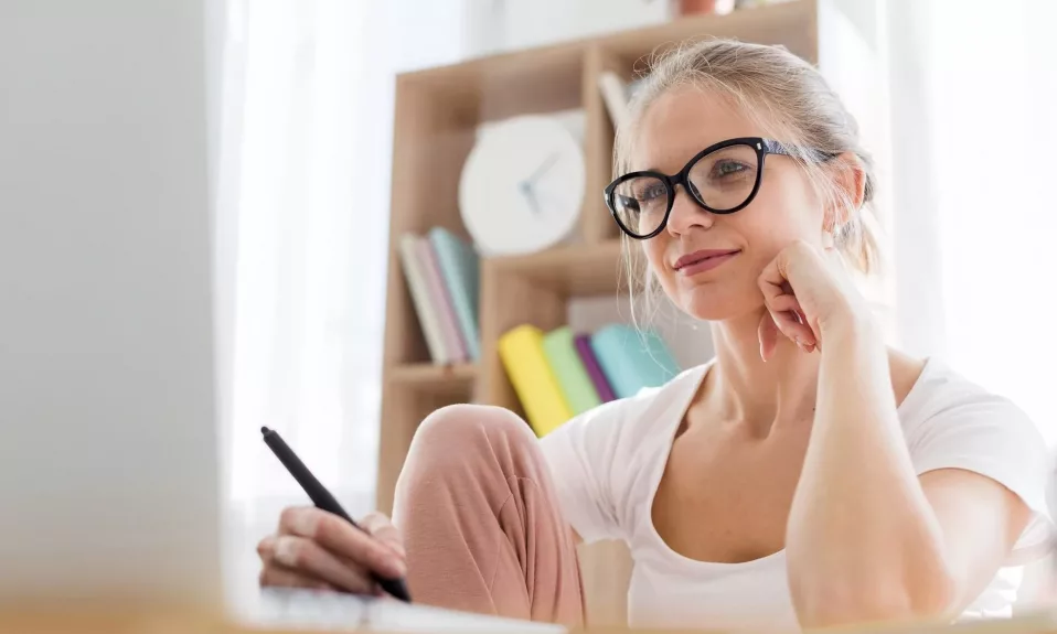 Woman wearing glasses working on laptop